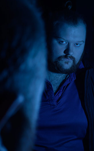 Man looking into mirror with the reflection looking back at him. 